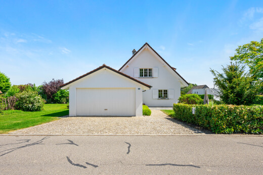 outdoor house featuring driveway, stucco siding, and a garage