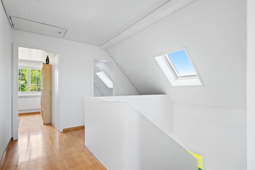 spare room with light wood-style floors, vaulted ceiling, and a skylight