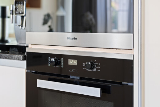 kitchen view of oven and stainless steel microwave