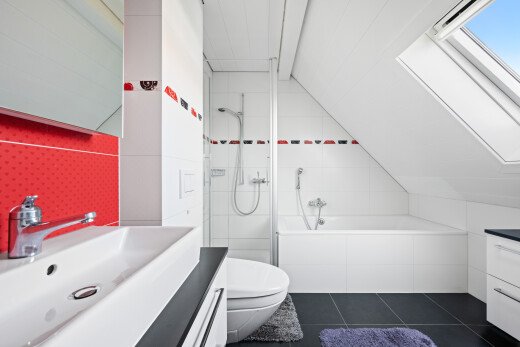 full bath featuring vanity, vaulted ceiling, tiled shower / bath combo, dark tile patterned flooring, and a skylight