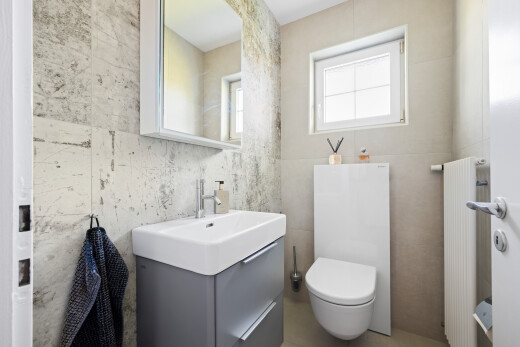half bathroom with vanity, tile walls, and radiator heating unit