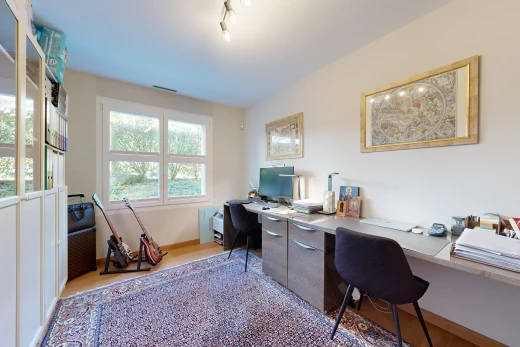 bureau avec plancher de bois, télévision, et lumière naturelle