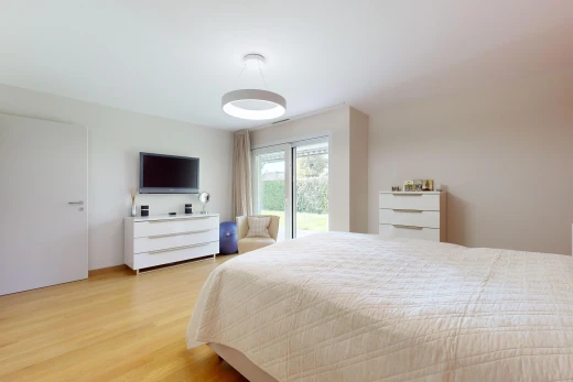 chambre avec lumière naturelle, télévision, et plancher de bois