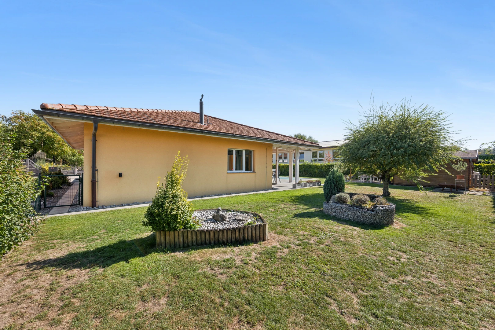 außenansicht mit property visible, rasen, from property, stuckverkleidung, und day time