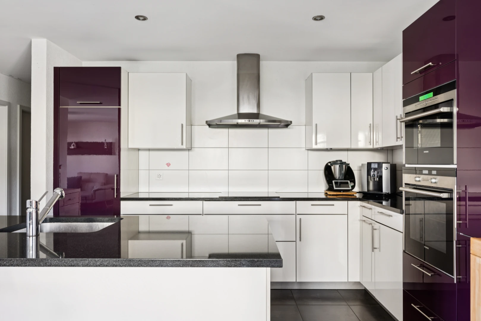 küche mit dunstabzugshaube, dark countertops, weiße schränke, white cabinets, und dark floor