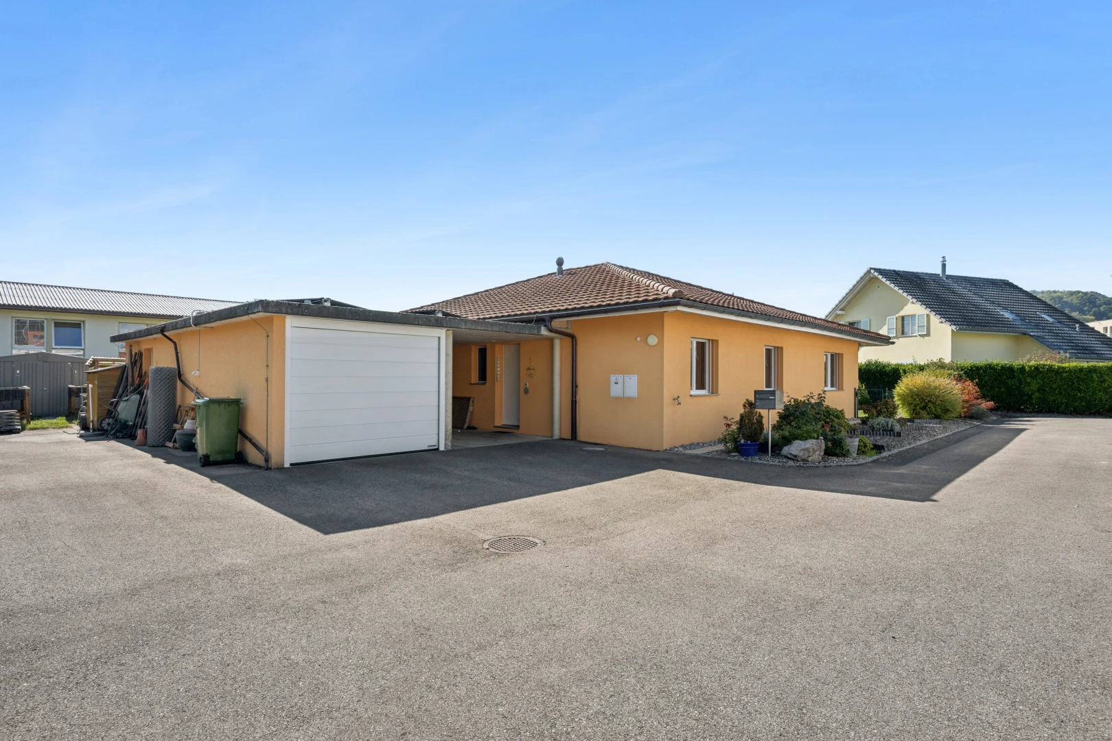 außenansicht mit garage angeschlossen, day time, stuckverkleidung, auffahrt, und ziegeldach