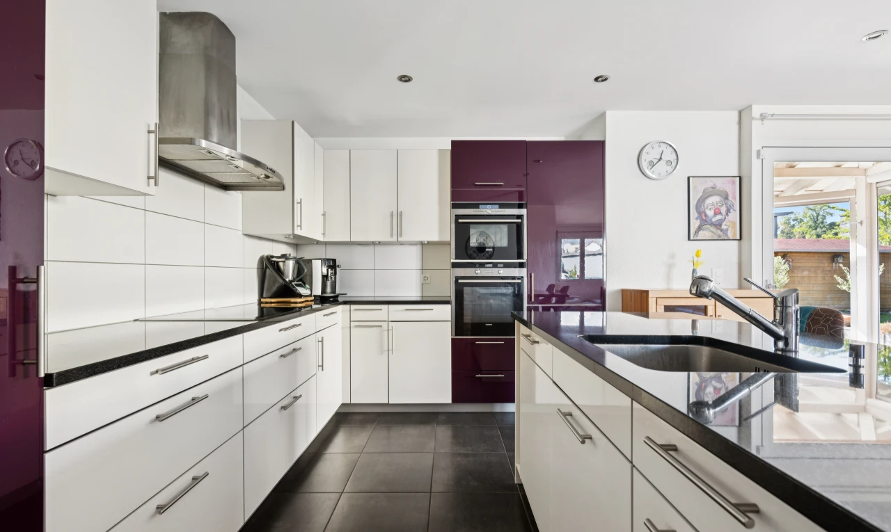 cuisine avec dark floor, hotte, dark countertops, évier, et armoires blanches