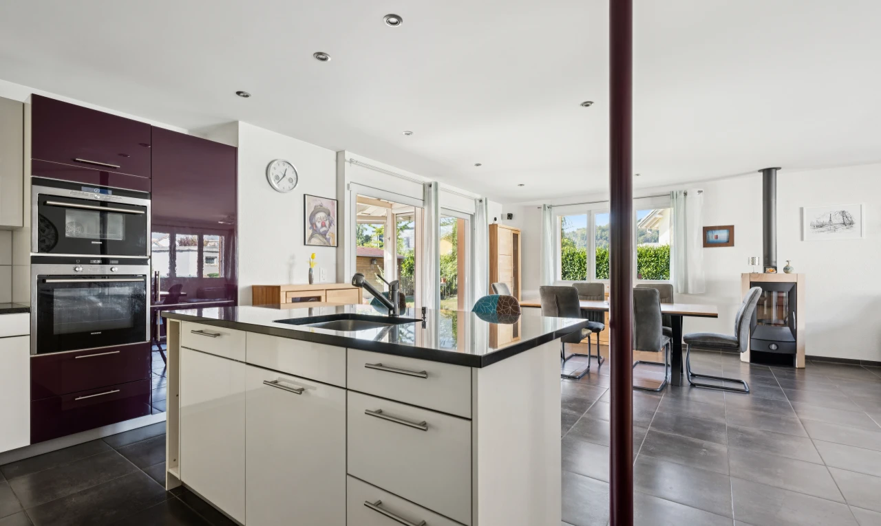 cuisine avec two tone kitchen, dark floor, dark countertops, évier, et white cabinets