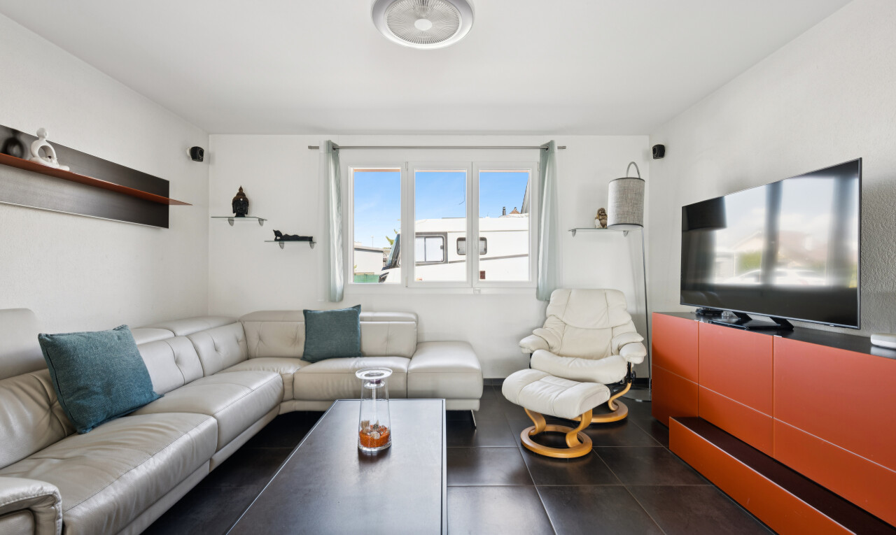 wohnzimmer mit fernseher, drywall, gipskartonwand, und dark floor