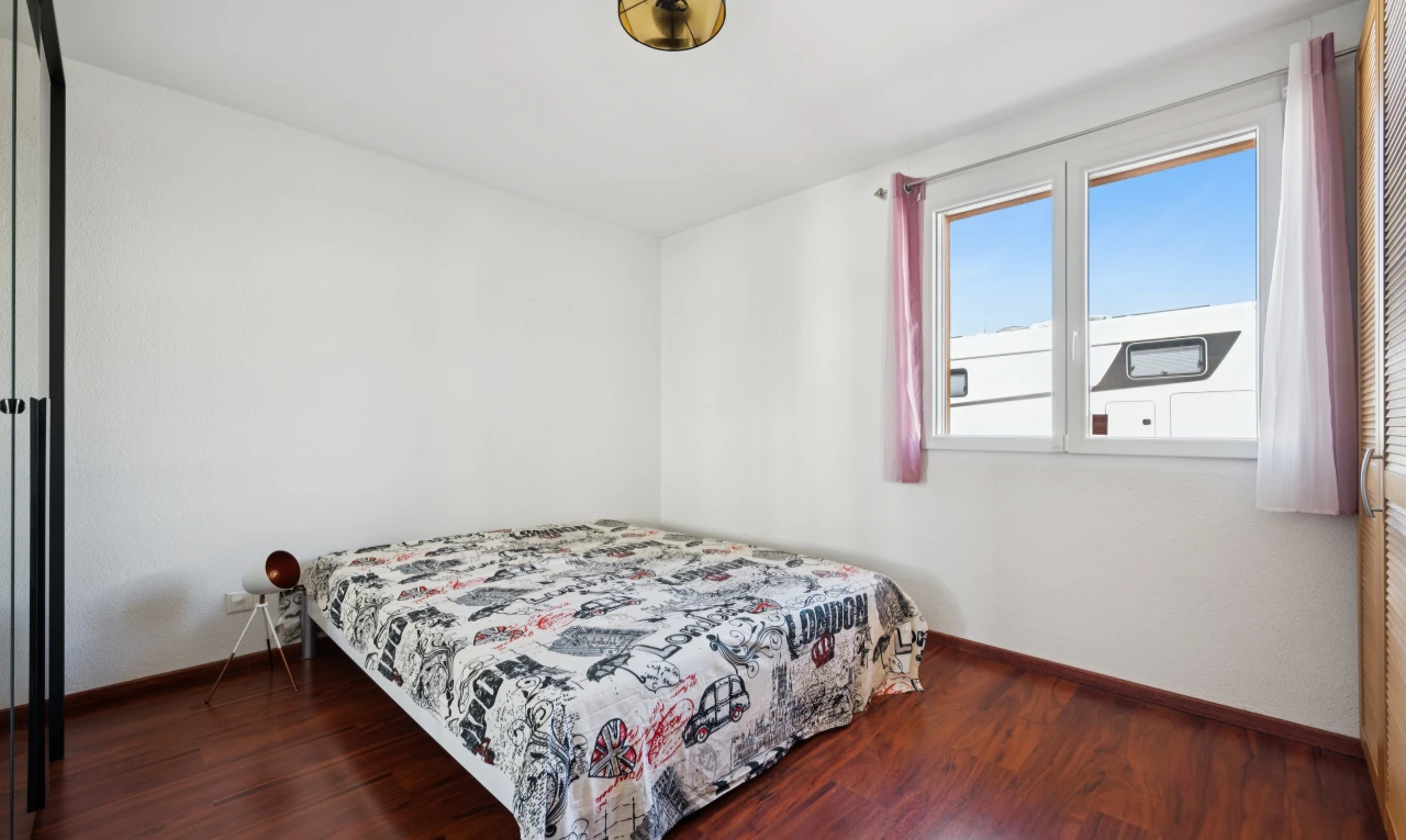 chambre avec wood finish floor, sol en finition bois, dark floor, drywall, et cloison sèche