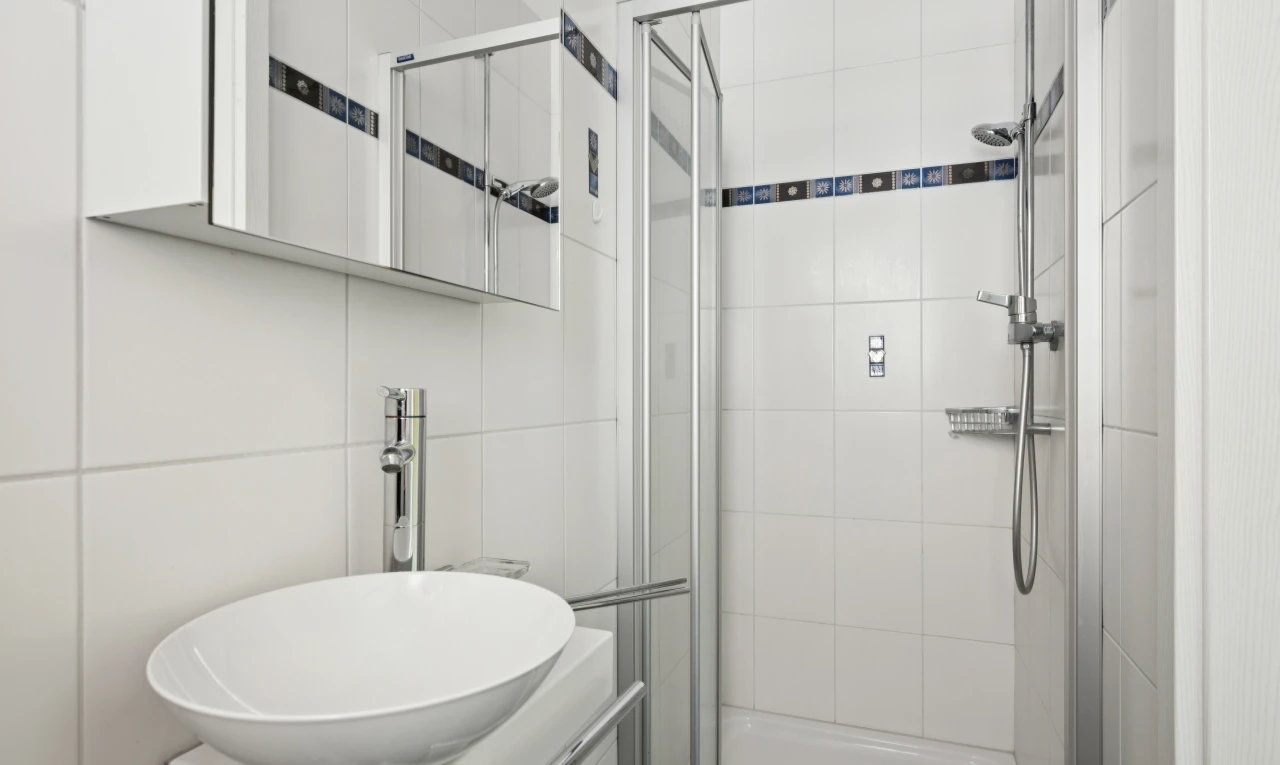 salle de bains avec douche, évier, miroir, salle de bain complète, et inside property