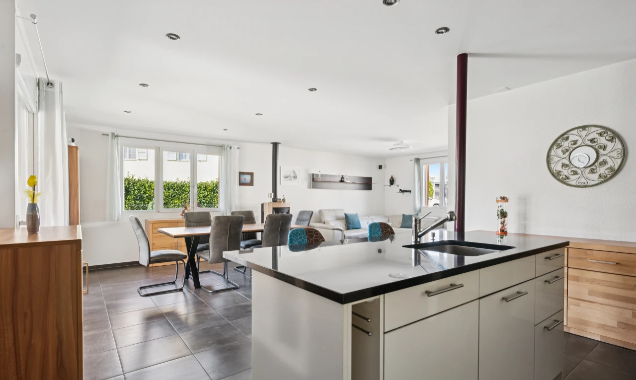 cuisine avec dark floor, kitchen island sink, drywall, cloison sèche, et évier