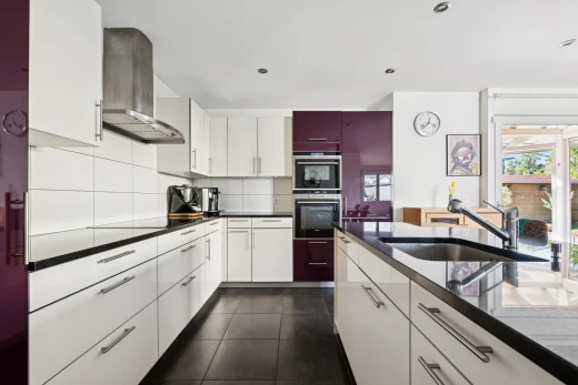 küche mit dark floor, dunstabzugshaube, dark countertops, waschbecken, und weiße schränke
