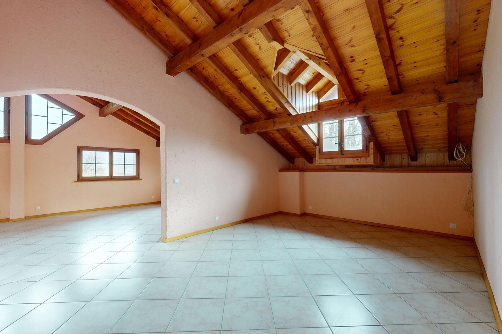 pièce vide avec passages en arc, lumière naturelle, plafond en bois, cloison sèche, et plafond voûté