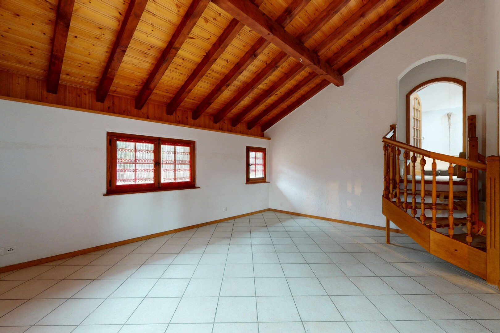 pièce vide avec plafond voûté, lumière naturelle, passages en arc, et plafond en bois
