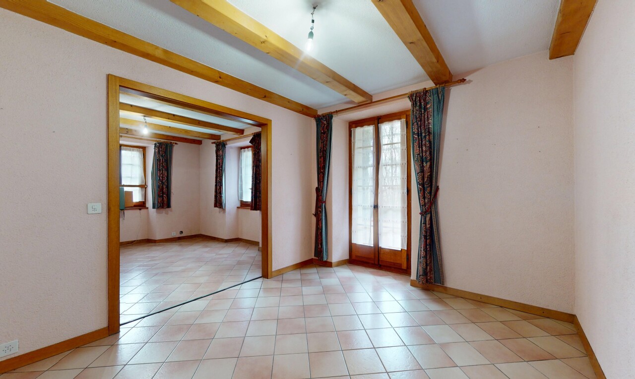 pièce vide avec lumière naturelle, cloison sèche, plafond à poutres, et plinthes murales
