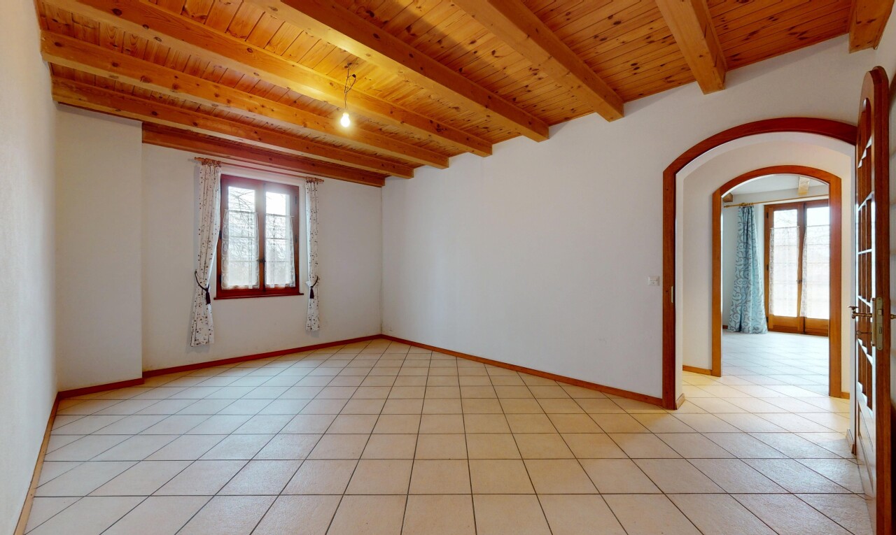 pièce vide avec plafond à poutres, passages en arc, lumière naturelle, plafond en bois, et cloison sèche