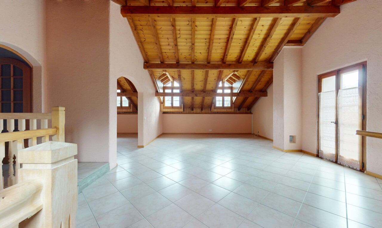 pièce vide avec passages en arc, plafond en bois, et plafond à poutres