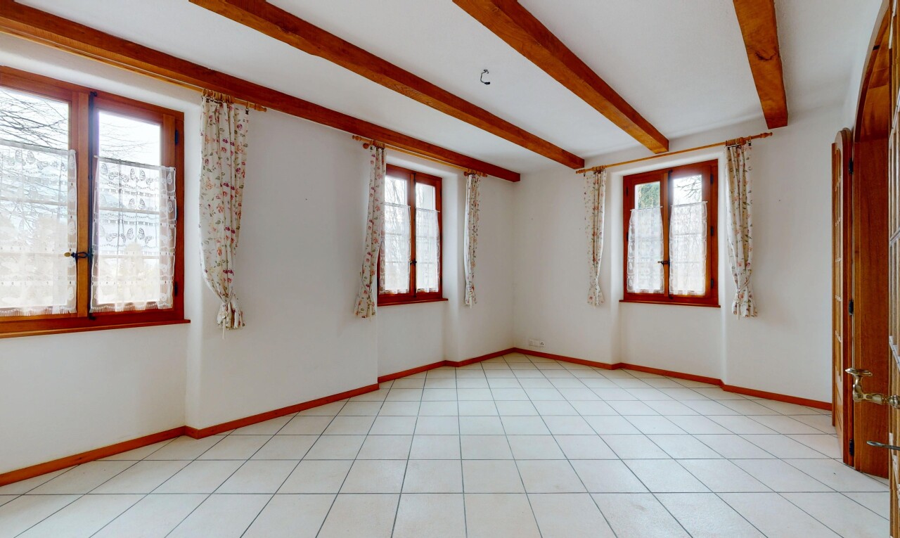 pièce vide avec cloison sèche, plafond à poutres, et lumière naturelle