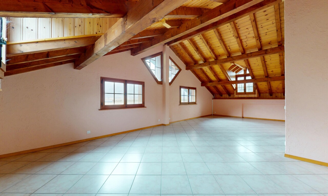 pièce vide avec plafond en bois, plafond voûté, plinthes murales, lumière naturelle, et plafond à poutres