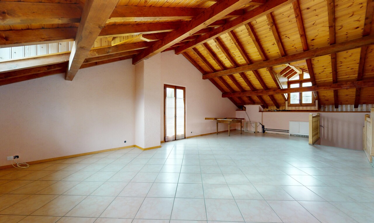 pièce vide avec lumière naturelle, plafond en bois, et cloison sèche