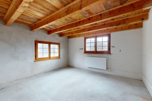 pièce vide avec sol en béton, plafond à poutres, radiateur, lumière naturelle, et plafond en bois