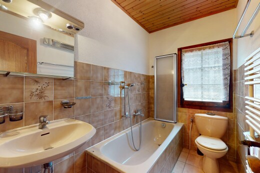 salle de bains avec sol en carrelage, plafond en bois, évier, mur en carrelage, et lumière naturelle