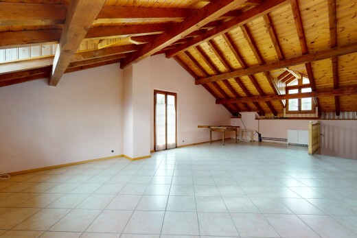 pièce vide avec lumière naturelle, plafond en bois, et cloison sèche