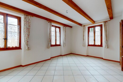 pièce vide avec cloison sèche, plafond à poutres, et lumière naturelle