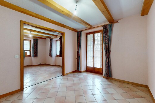 pièce vide avec lumière naturelle, cloison sèche, plafond à poutres, et plinthes murales