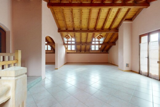 pièce vide avec passages en arc, plafond en bois, et plafond à poutres