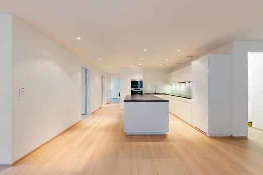 küche mit l-förmige küche, weiße schränke, kücheninsel, inside property, und wood finish floor