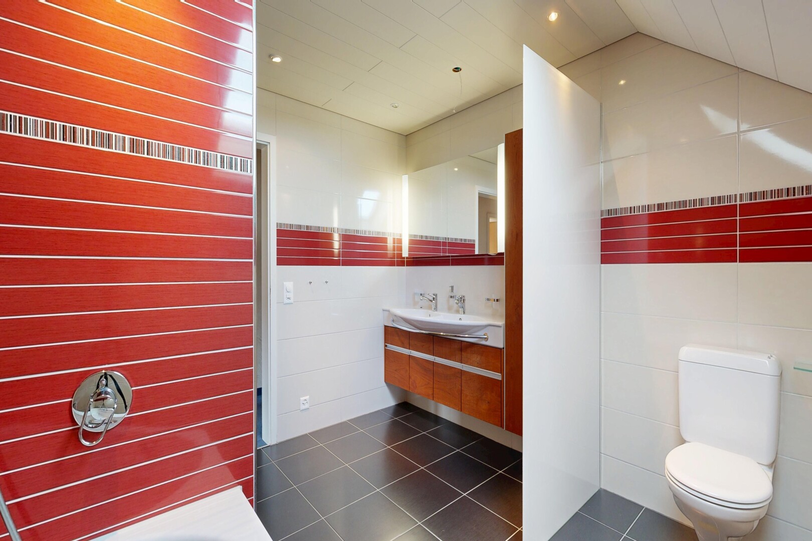 salle de bains avec miroir, toilette, lavabo (ou coiffeuse selon le contexte), tile floor, et dark floor