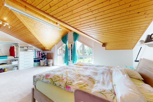 chambre avec lumière naturelle, moquette, éclairage sur rail, et plafond en bois
