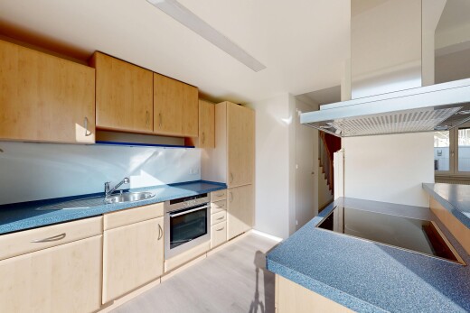 küche mit hellbraune schränke, dunstabzugshaube, ofen, inside property, und wood finish floor