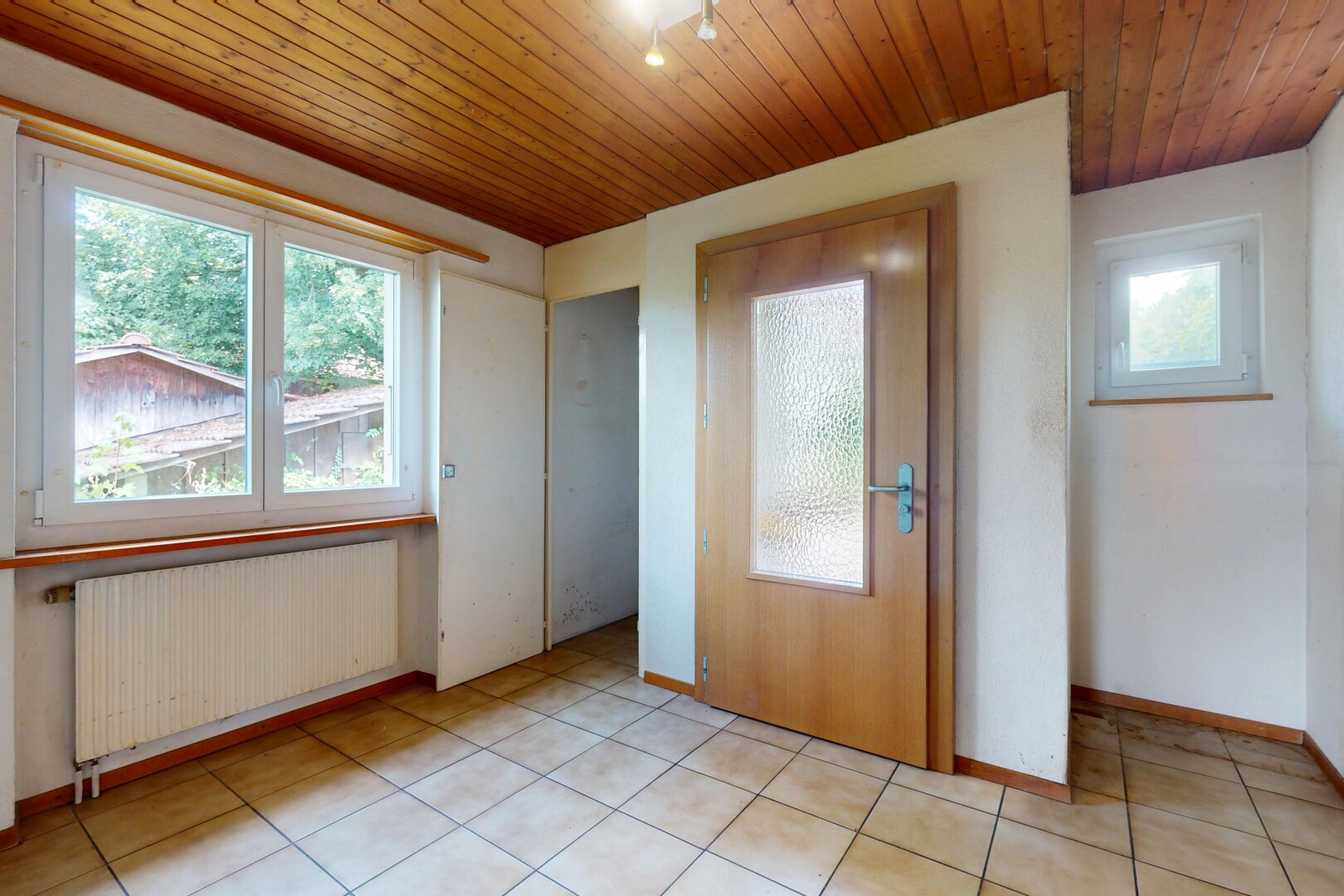 pièce vide avec radiateur, wood ceiling, plafond en bois, inside property, et baseboards wall