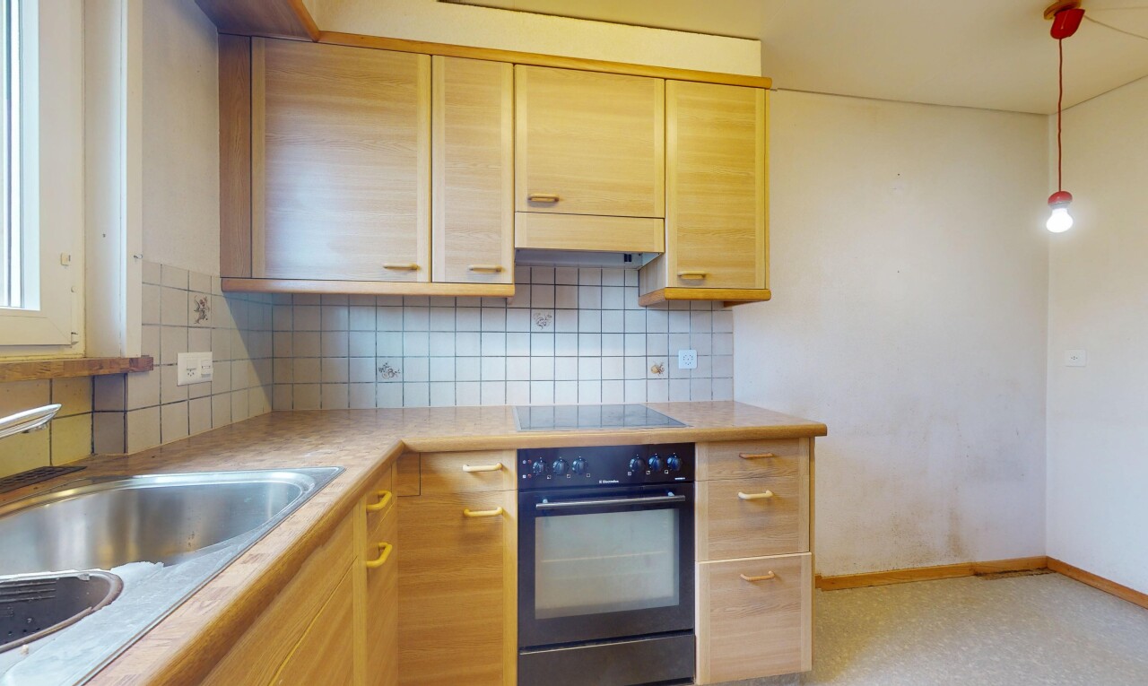 cuisine avec four, armoires marron clair, backsplash, dosseret, et inside property