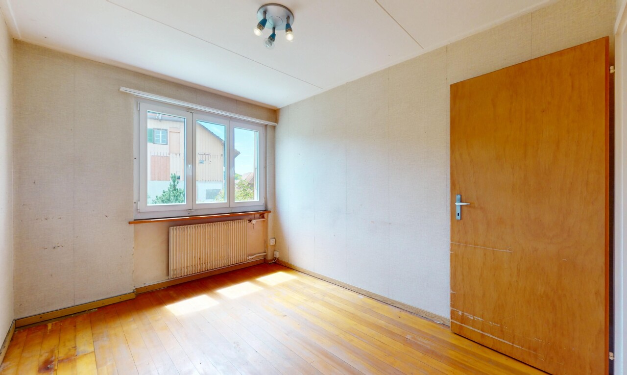 pièce vide avec natural light, lumière naturelle, radiateur, wood finish floor, et sol en finition bois