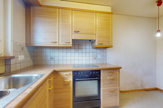 cuisine avec four, armoires marron clair, backsplash, dosseret, et inside property