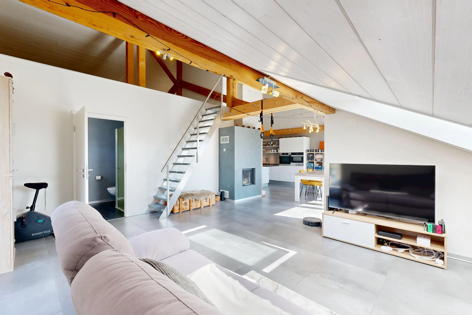 salon avec escaliers, télévision, drywall, cloison sèche, et vaulted ceiling