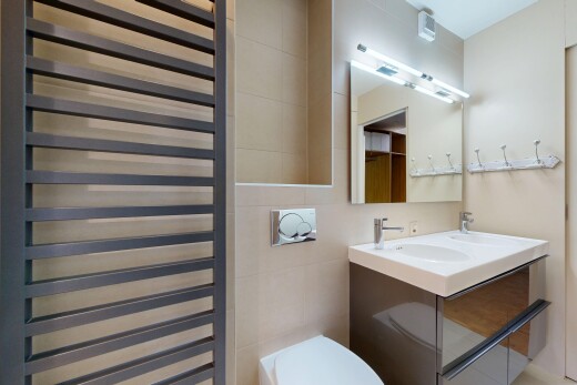 salle de bains avec radiateur, miroir, toilette, double vasque, et inside property