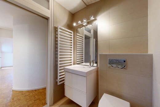 salle de bains avec miroir, radiateur, lavabo (ou coiffeuse selon le contexte), parquet floor, et toilette