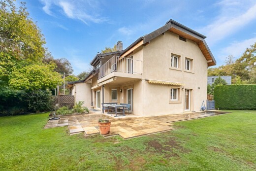 façade avec balcon, bardage en stuc, terrasse, pelouse, et property visible