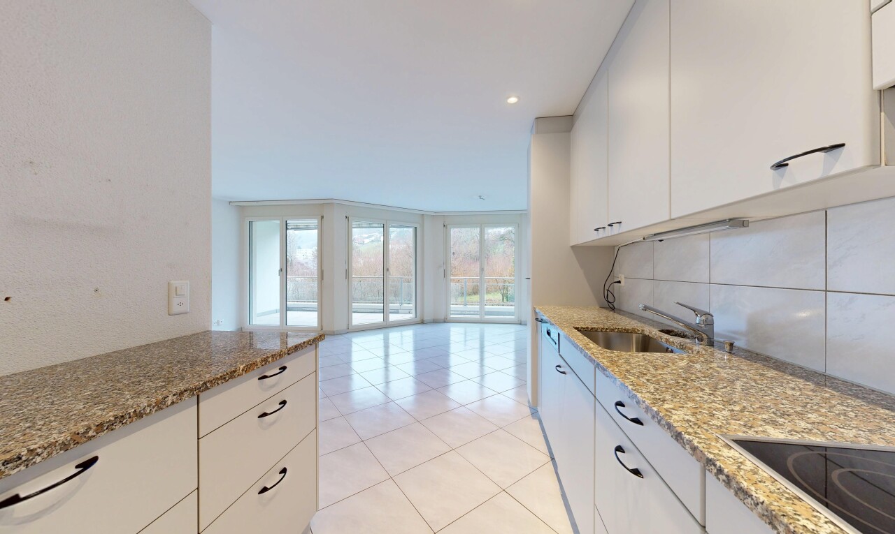 cuisine avec dosseret, backsplash, plans de travail en pierre, plaque de cuisson, et armoires blanches