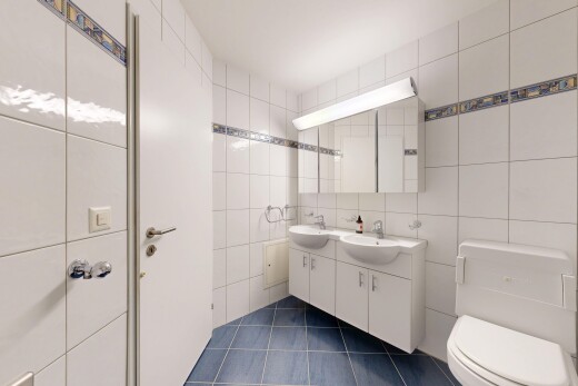 salle de bains avec double vasque, mur en carrelage, tile wall, toilette, et sol en carrelage