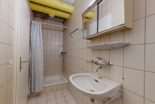 bad mit fliesenböden, waschbecken, duschvorhang, spiegel und bade- / duschkombination