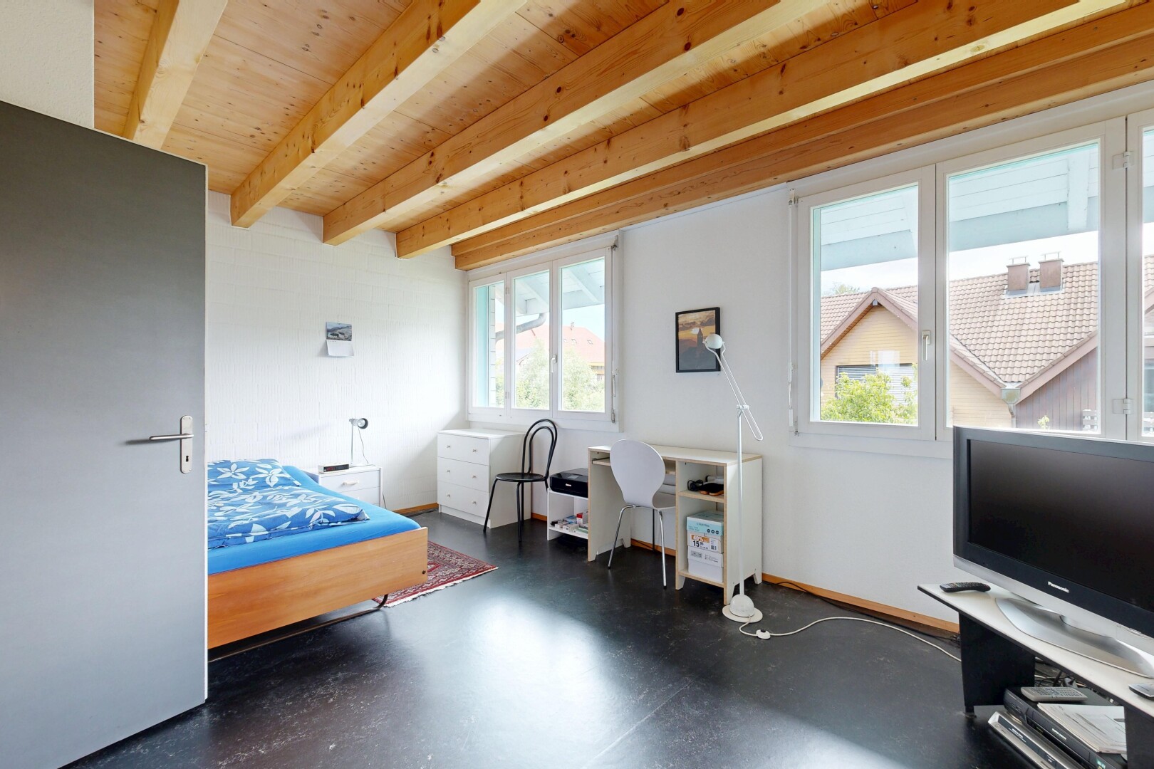zimmer / schlafzimmer mit finished concrete floor, betonboden, concrete floor, balkendecke, und beamed ceiling