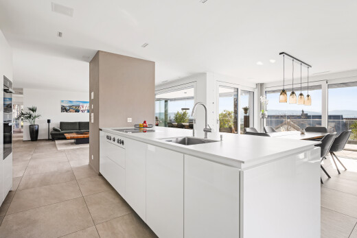 kitchen with light countertops, open floor plan, white cabinetry, modern cabinets, and hanging light fixtures
