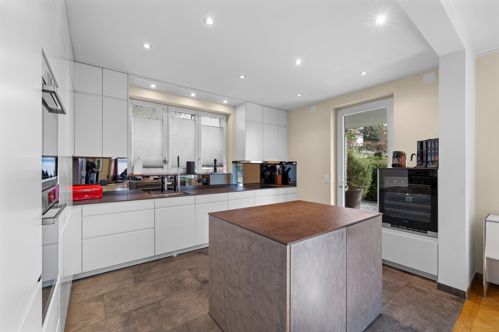 cuisine avec dark floor, flat panel cabinets, armoires à panneau plat, inside property, et drywall