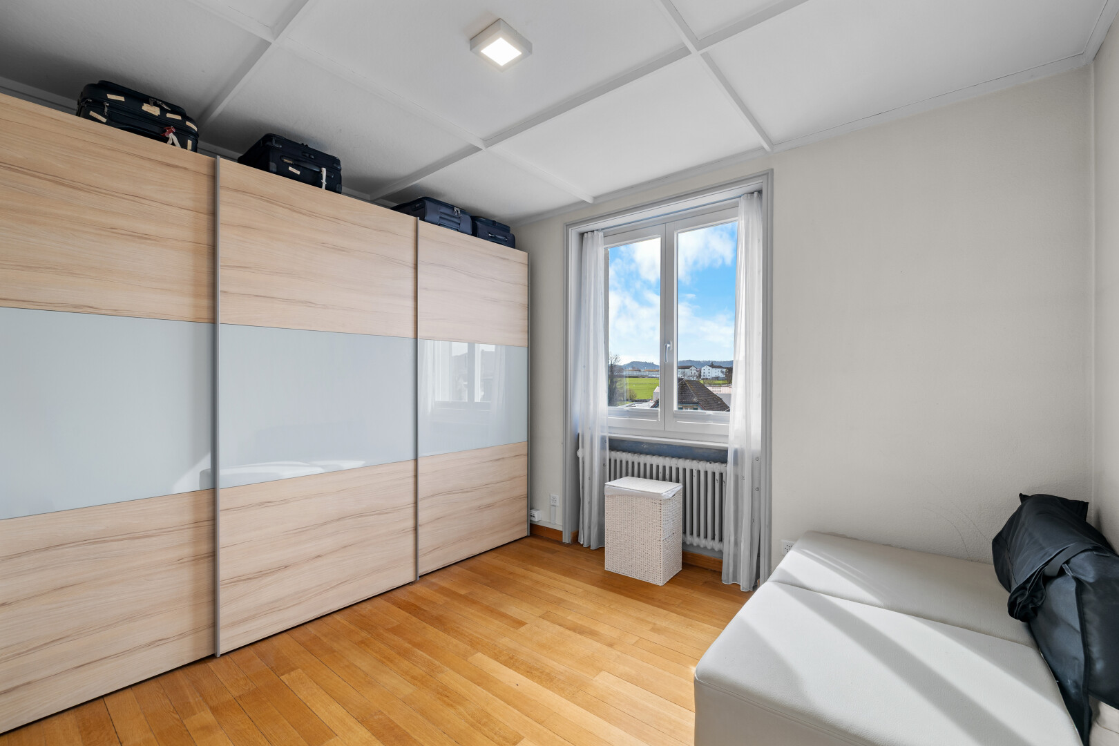 chambre avec day time, inside property, sol en finition bois, wood finish floor, et radiateur